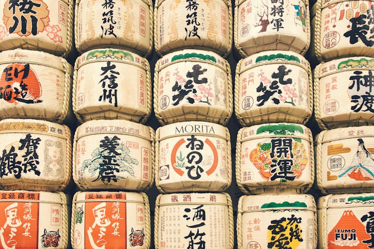 Colorful display of traditional Japanese sake barrels stacked in a cultural setting.