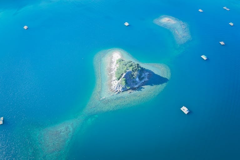 Stunning aerial shot of a small island surrounded by clear blue ocean near Naruto, Japan.
